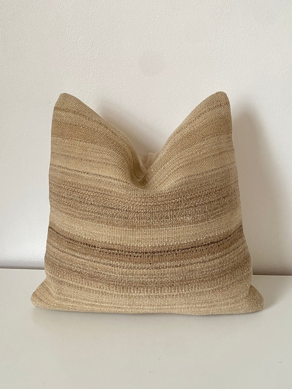 Textured beige stripe pillow on a white background