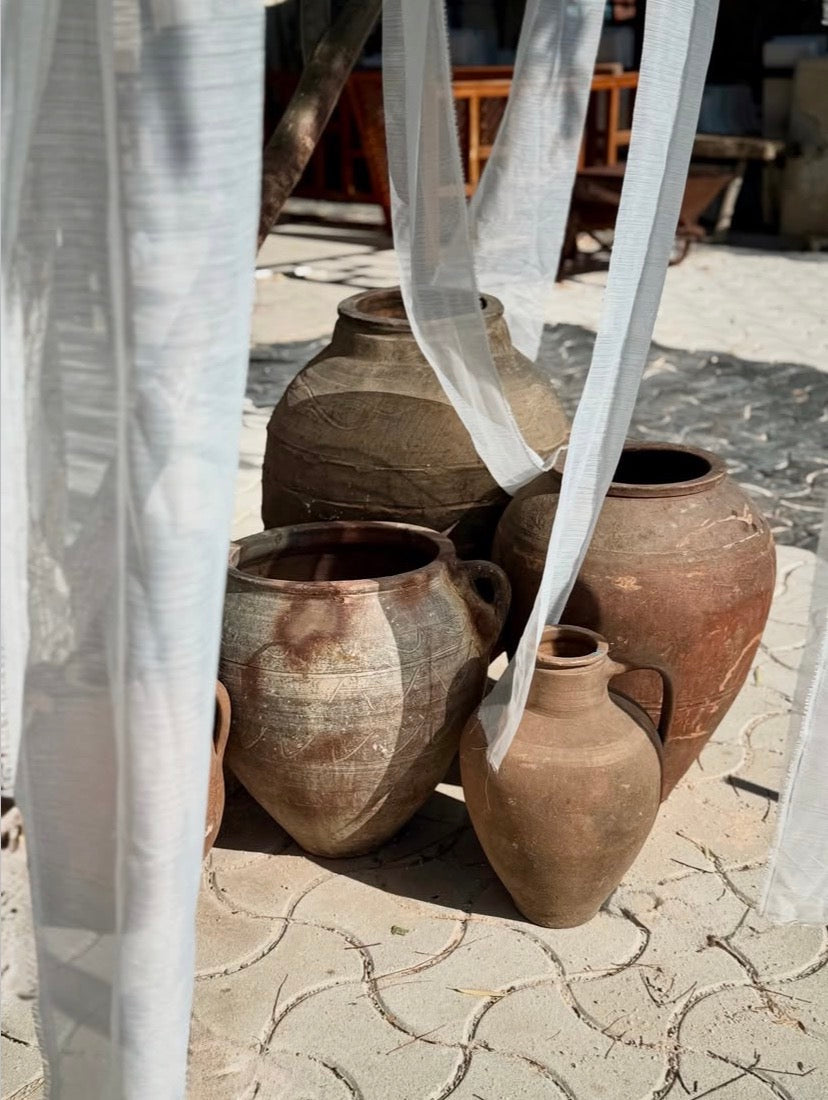 A Cluster of antique clay pots on cobbled flooring