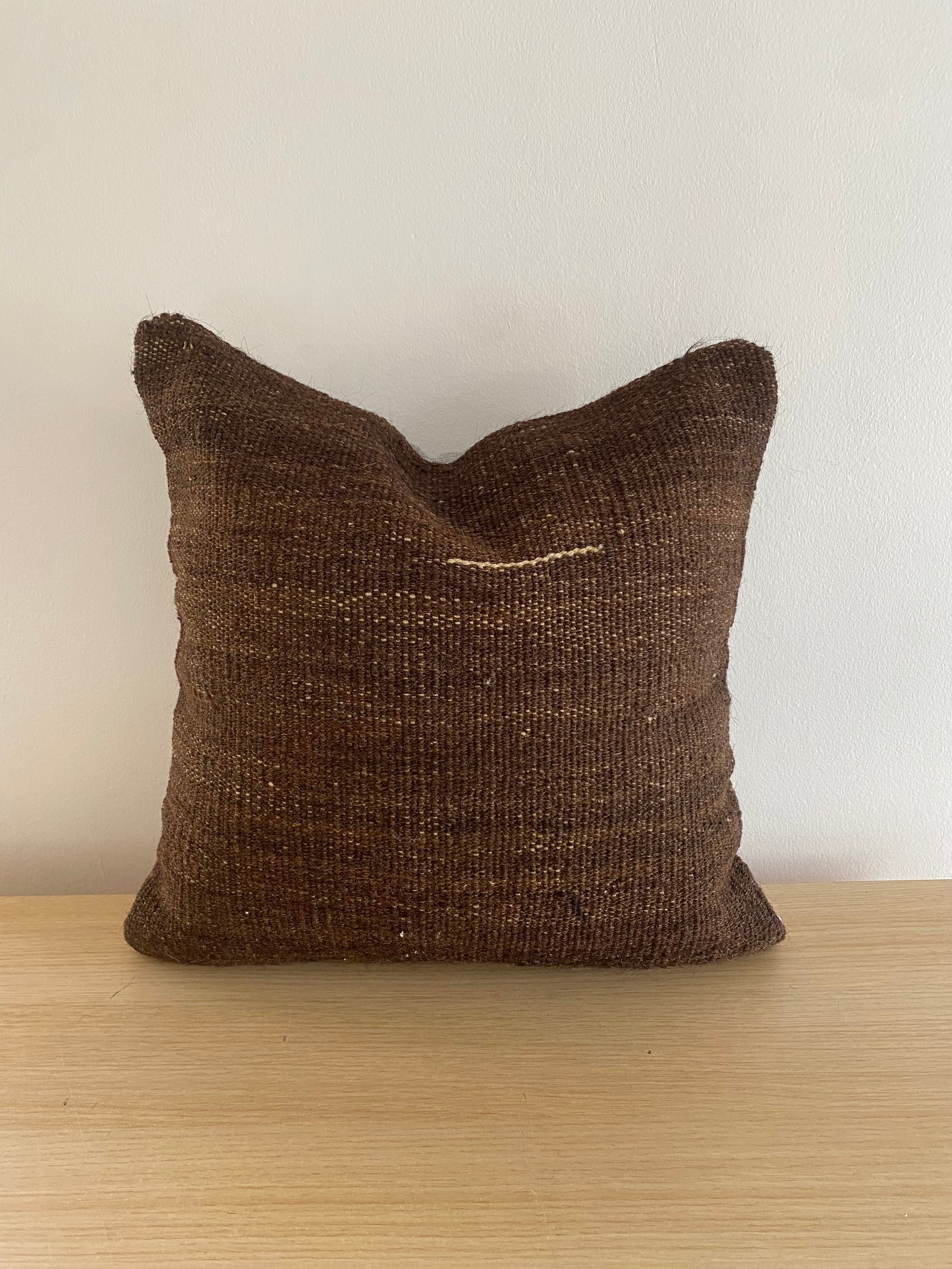 Brown textured Turkish Pillow Cover on a wooden surface with a neutral background