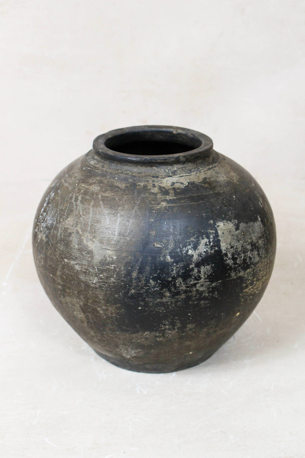 Black brown antique clay pot on a white background