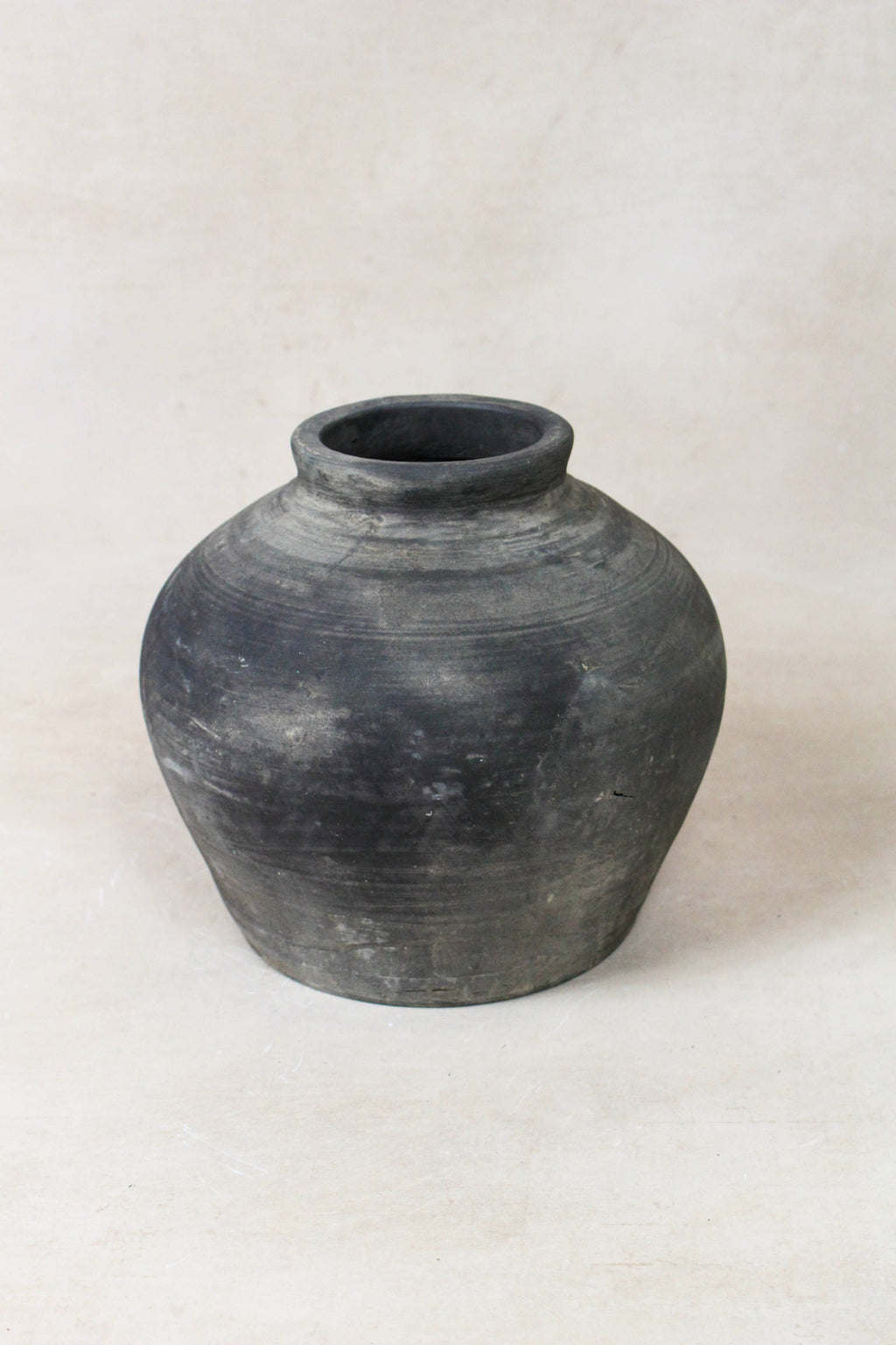 Black grey clay pot on a white background