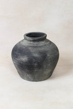 Black grey clay pot on a white background