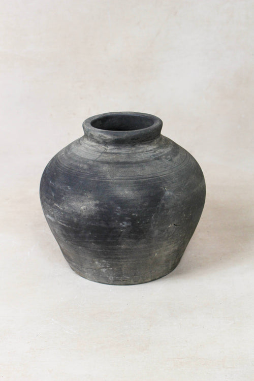 Black grey clay pot on a white background