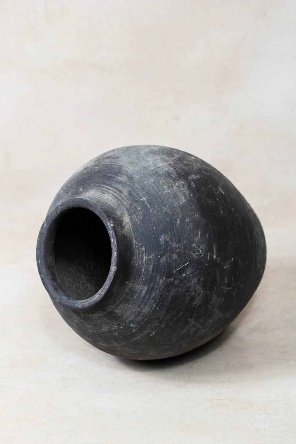 Black great clay pot on a light gray background