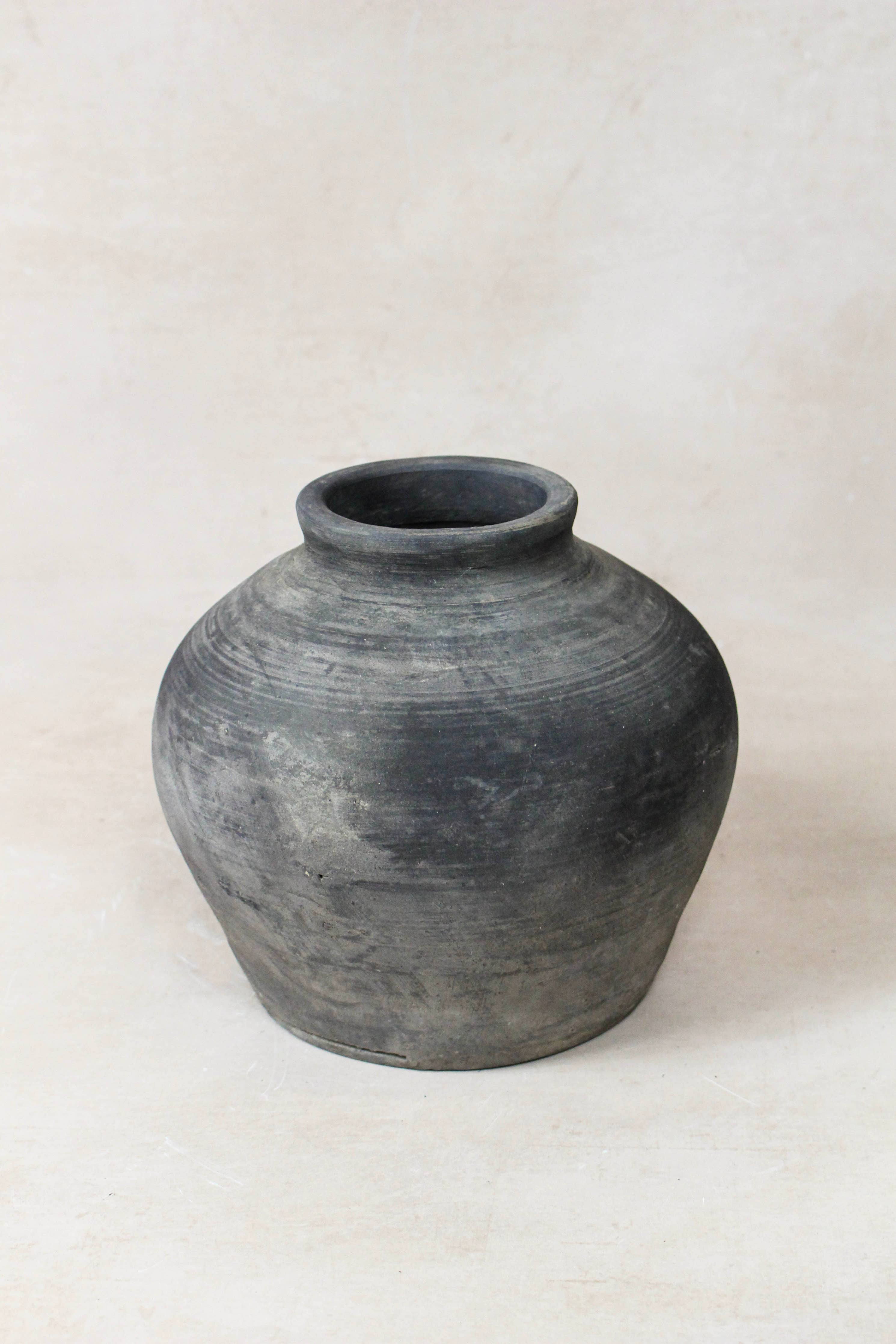 Black grey antique clay pot on a white background