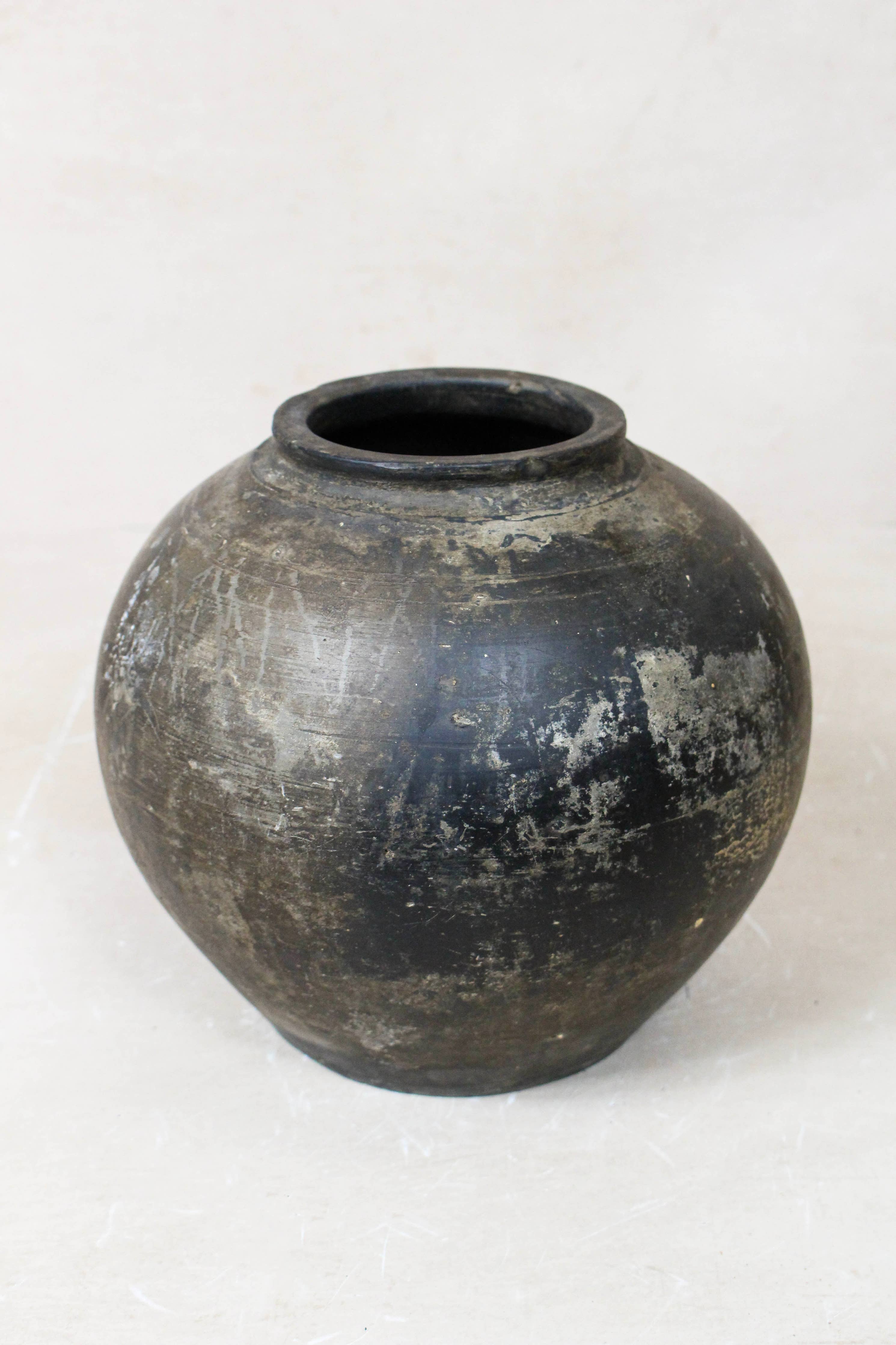 Black brown antique terracotta clay pot on a white background