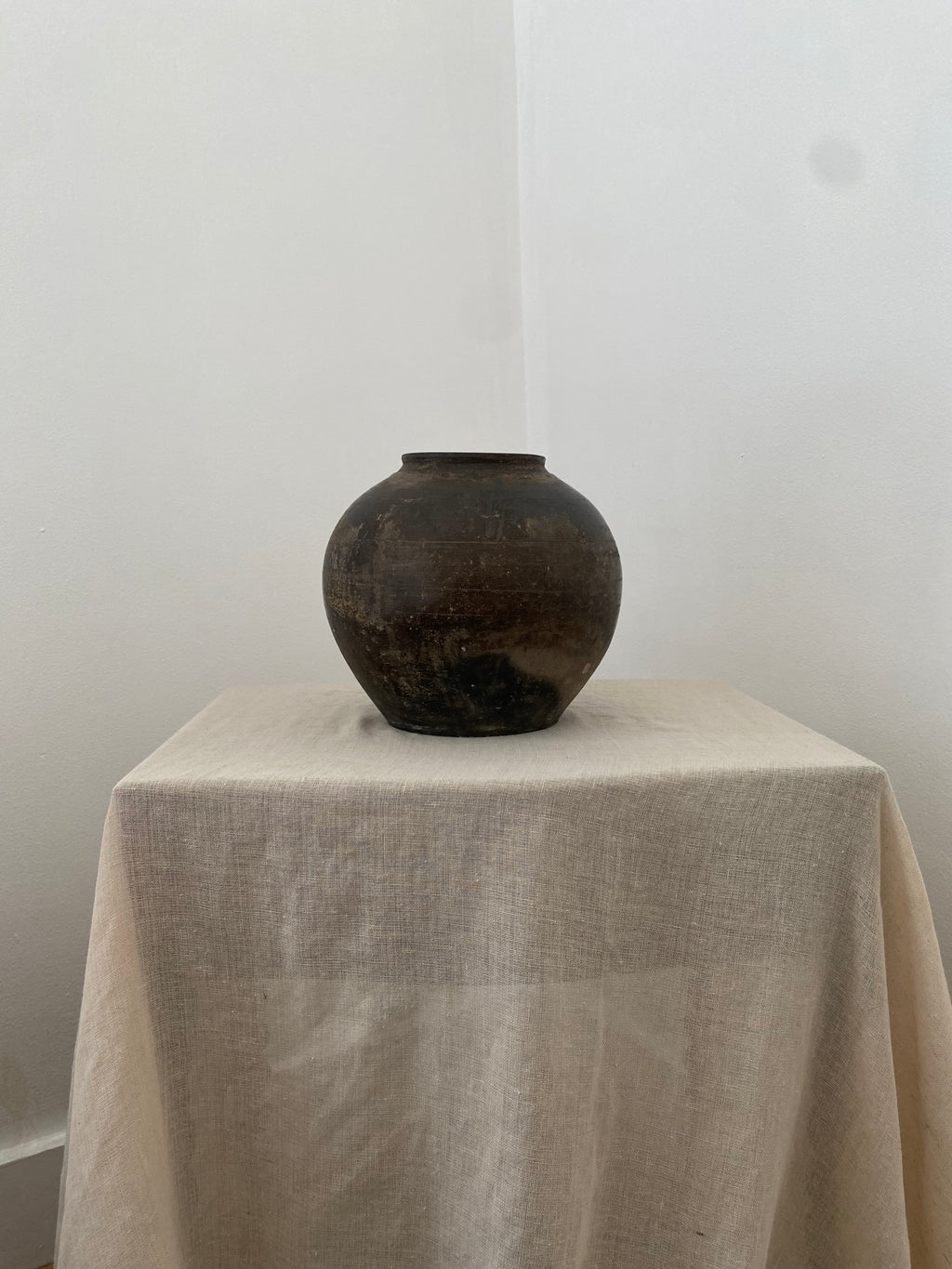 Dark brown vintage terracotta clay pot on a white surface