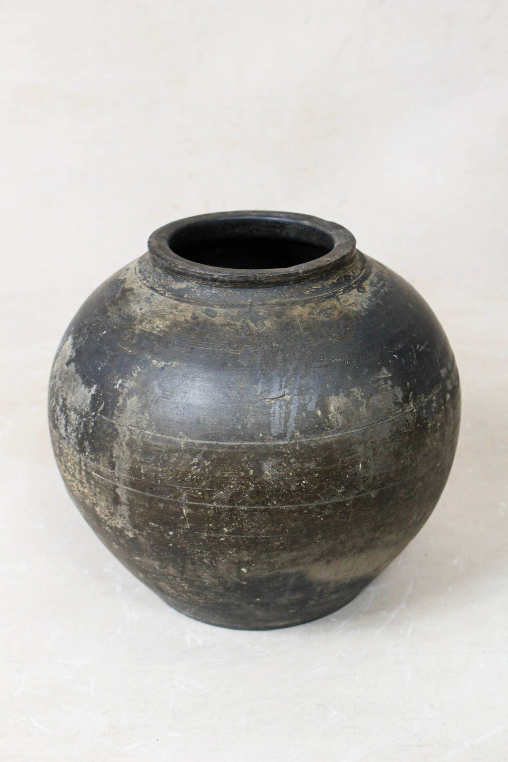 Black earthenware clay pot on a white background