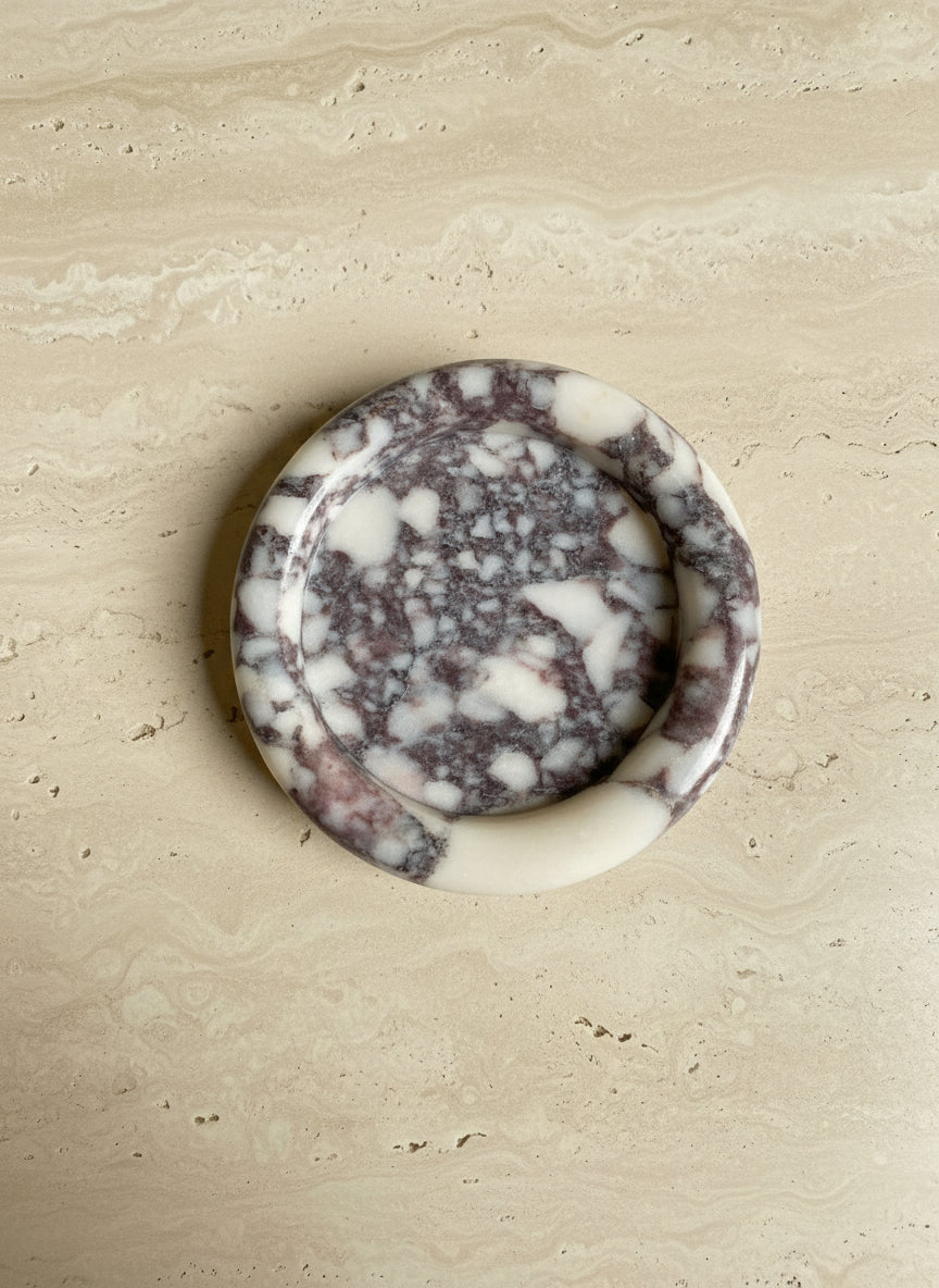 Round Calcutta Marble-patterned tray on a book titled 'The Art of Home'