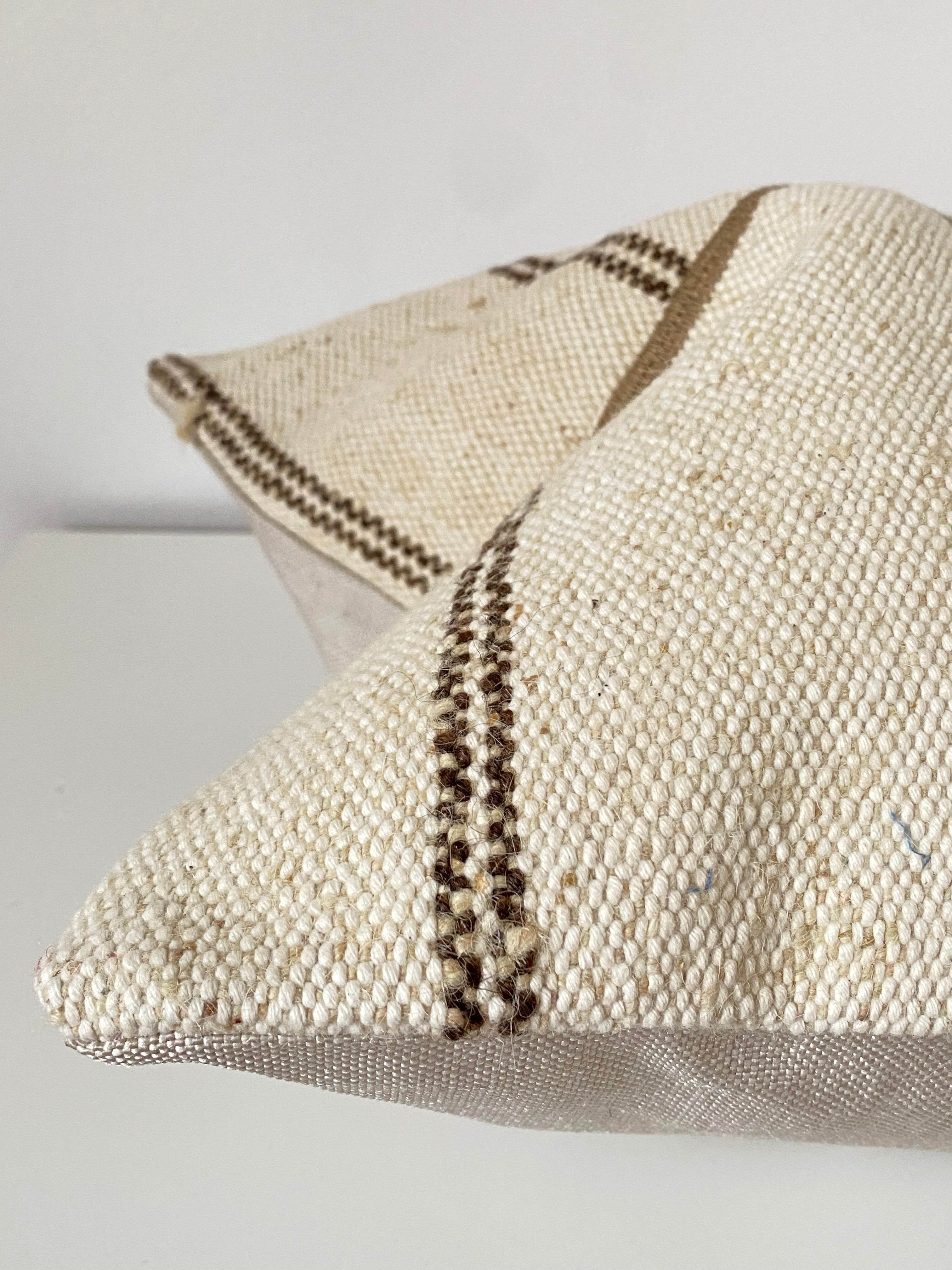 Textured Turkish Kilim pillow cover with a subtle brown striped pattern on a plain background