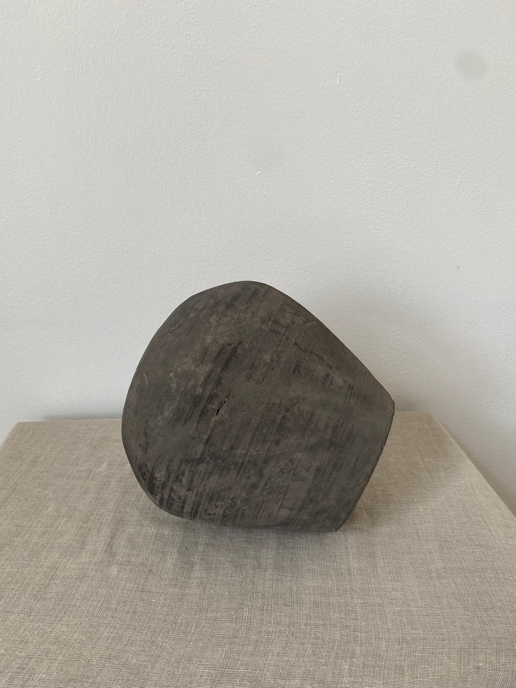 Dark gray antique clay pot  on a light beige linen cloth
