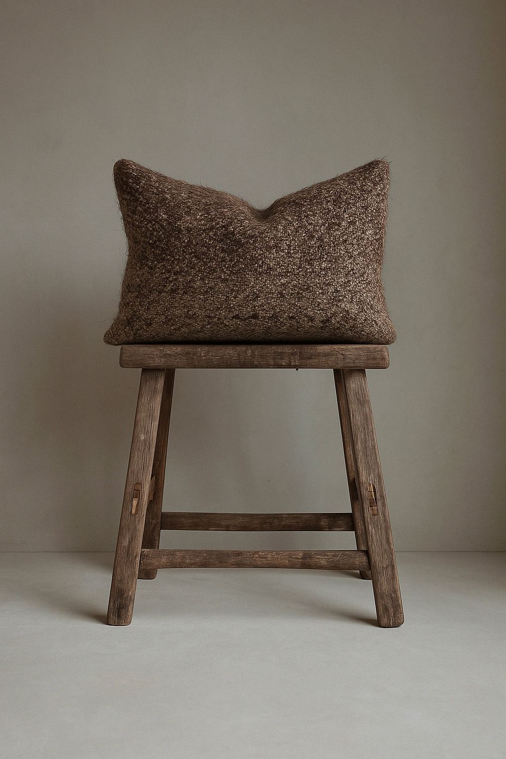 Handwoven brown kilim cushion with natural wool and goat hair blend, textured for rustic interiors. A vintage-style lumbar cushion for neutral home decor.
