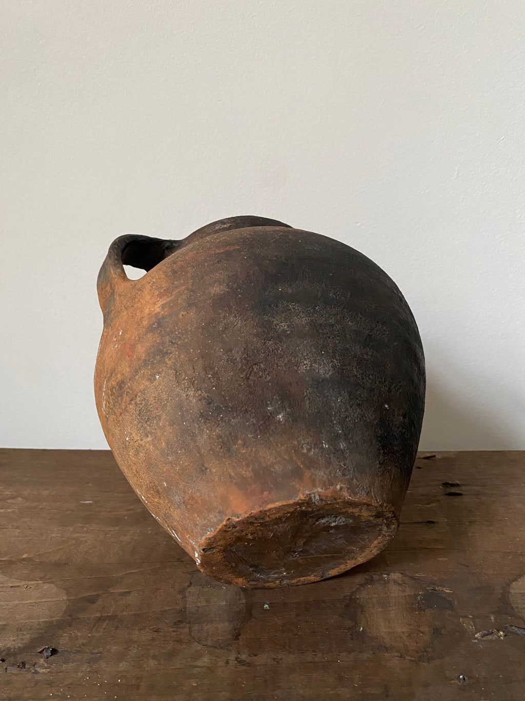 Black antique pot on a wooden surface with a white background