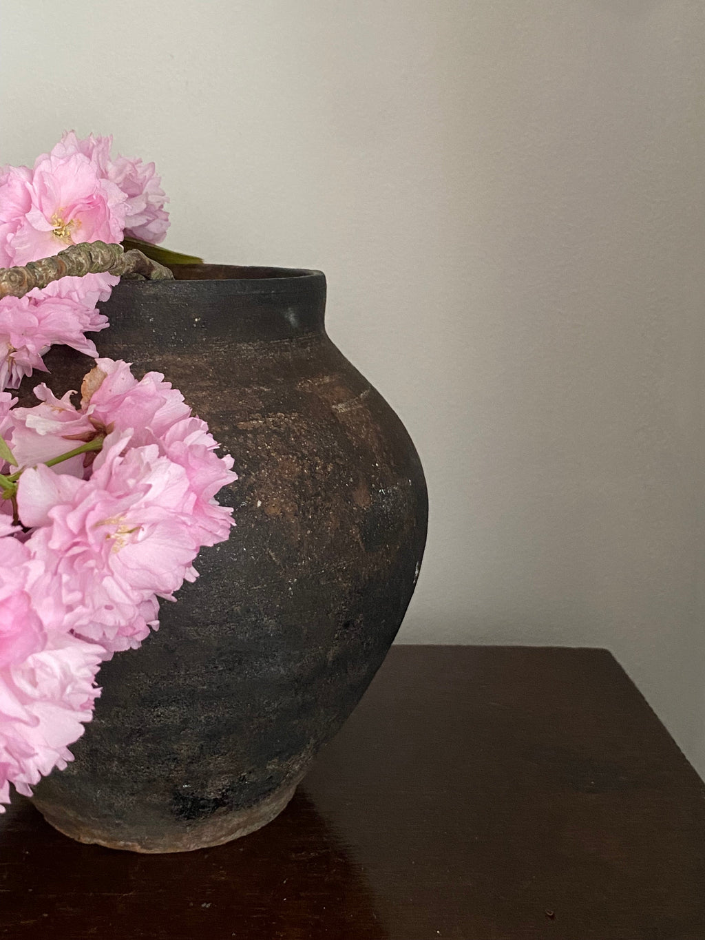 Closeup of an Antique terracotta clay pot on a wooden table