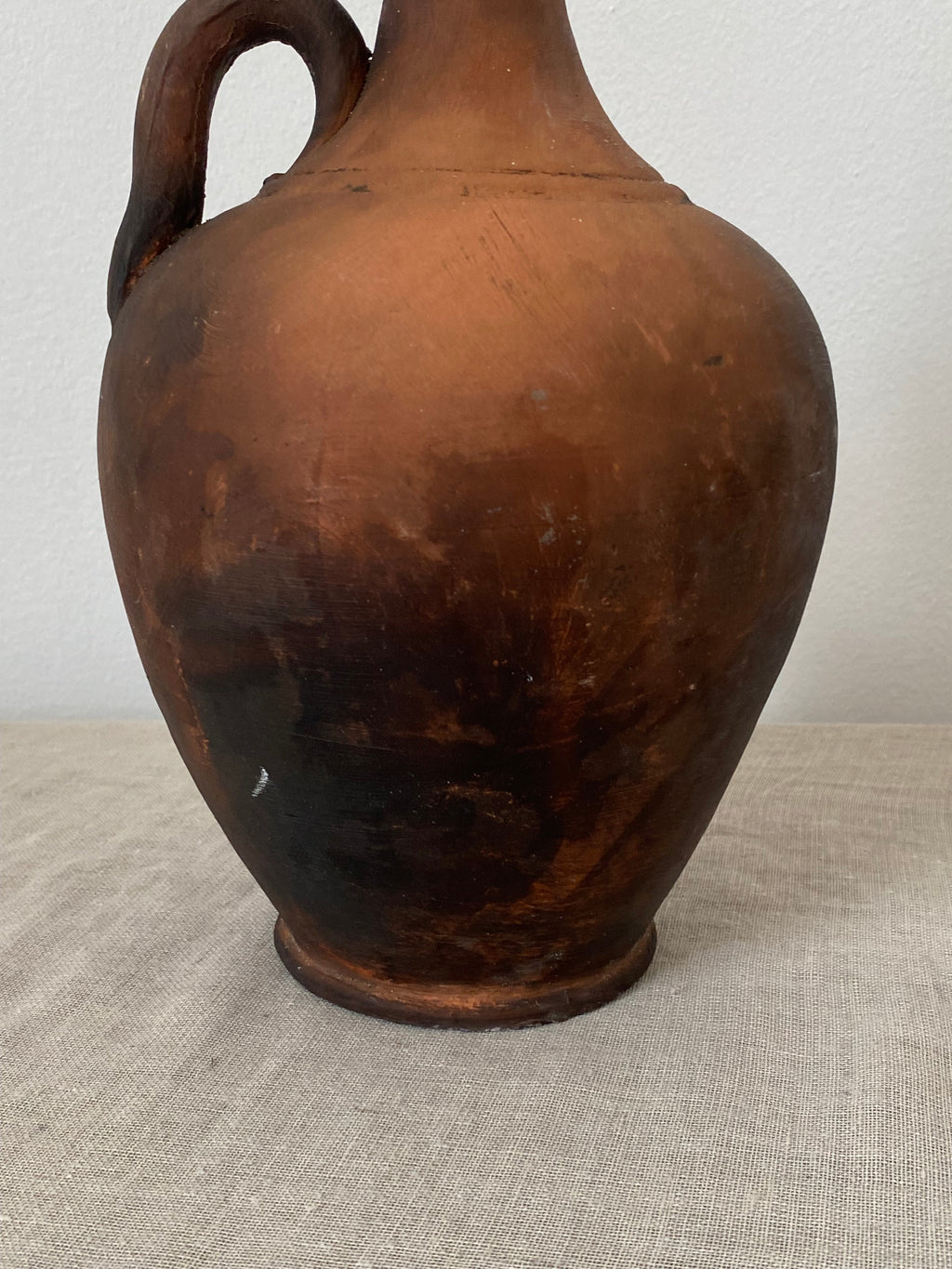 Brown terracotta clay ptcher on a linen cloth