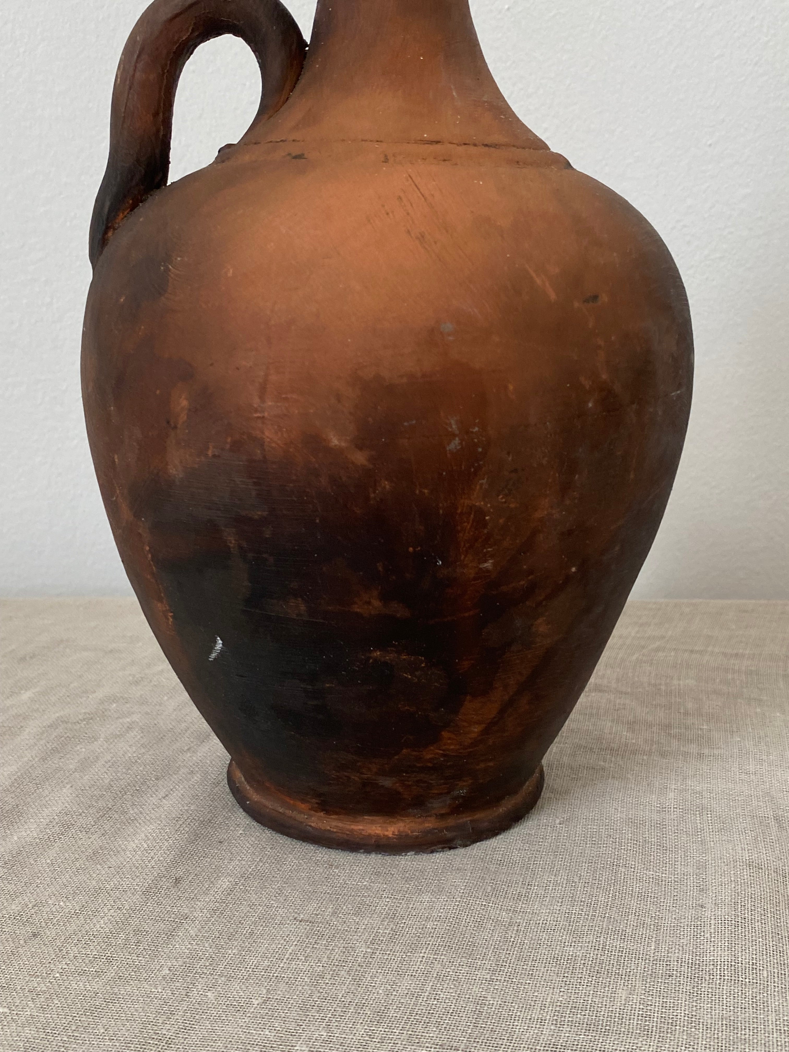 Brown terracotta clay ptcher on a linen cloth