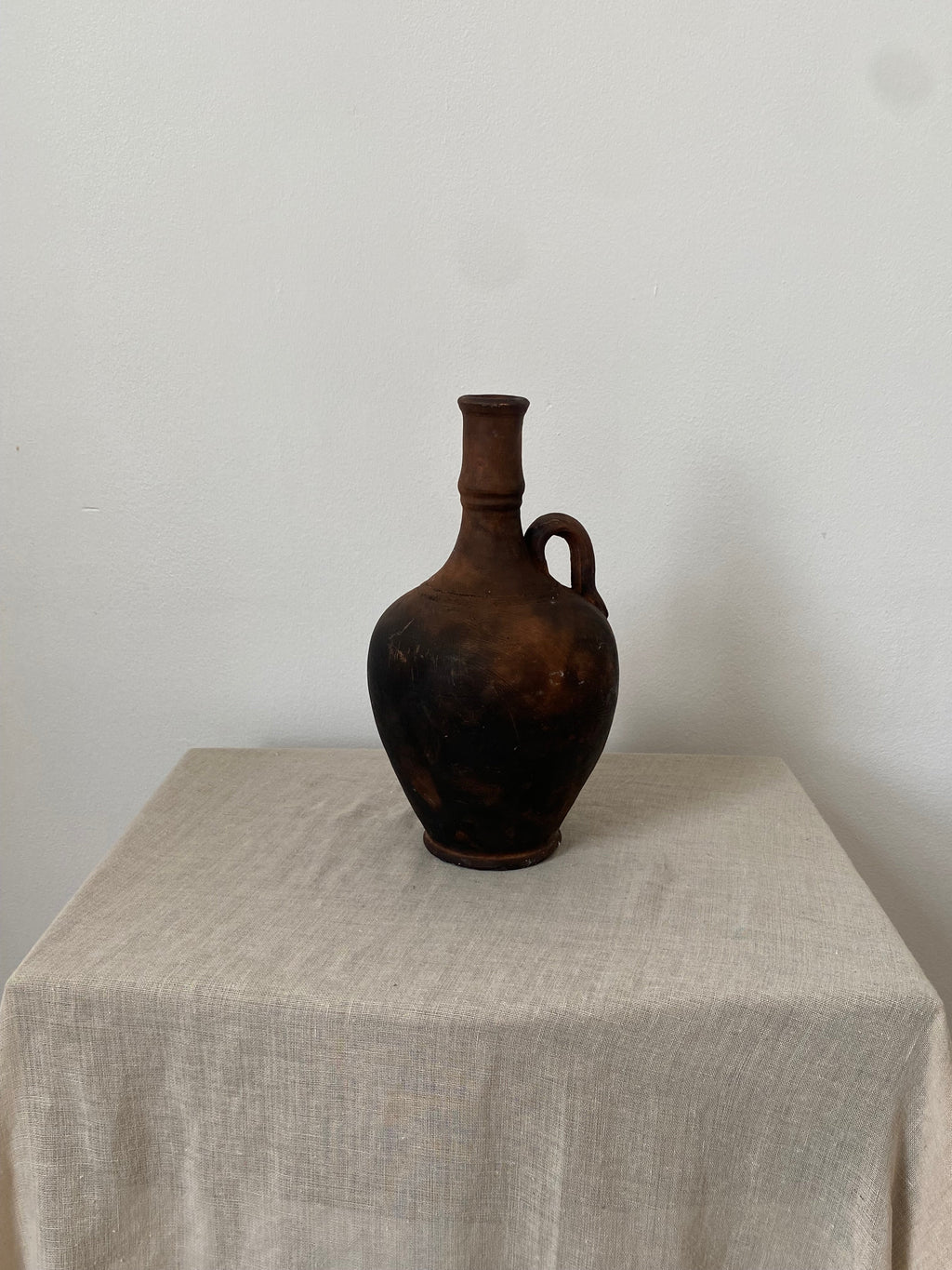 Brown antique terracotta clay pot on a textured gray surface with a white background
