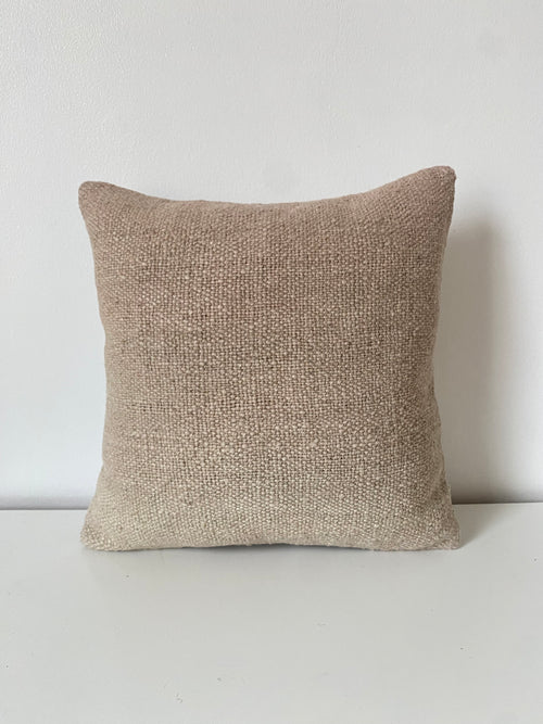 Textured beige Turkish Kilim pillow cover on a light gray background