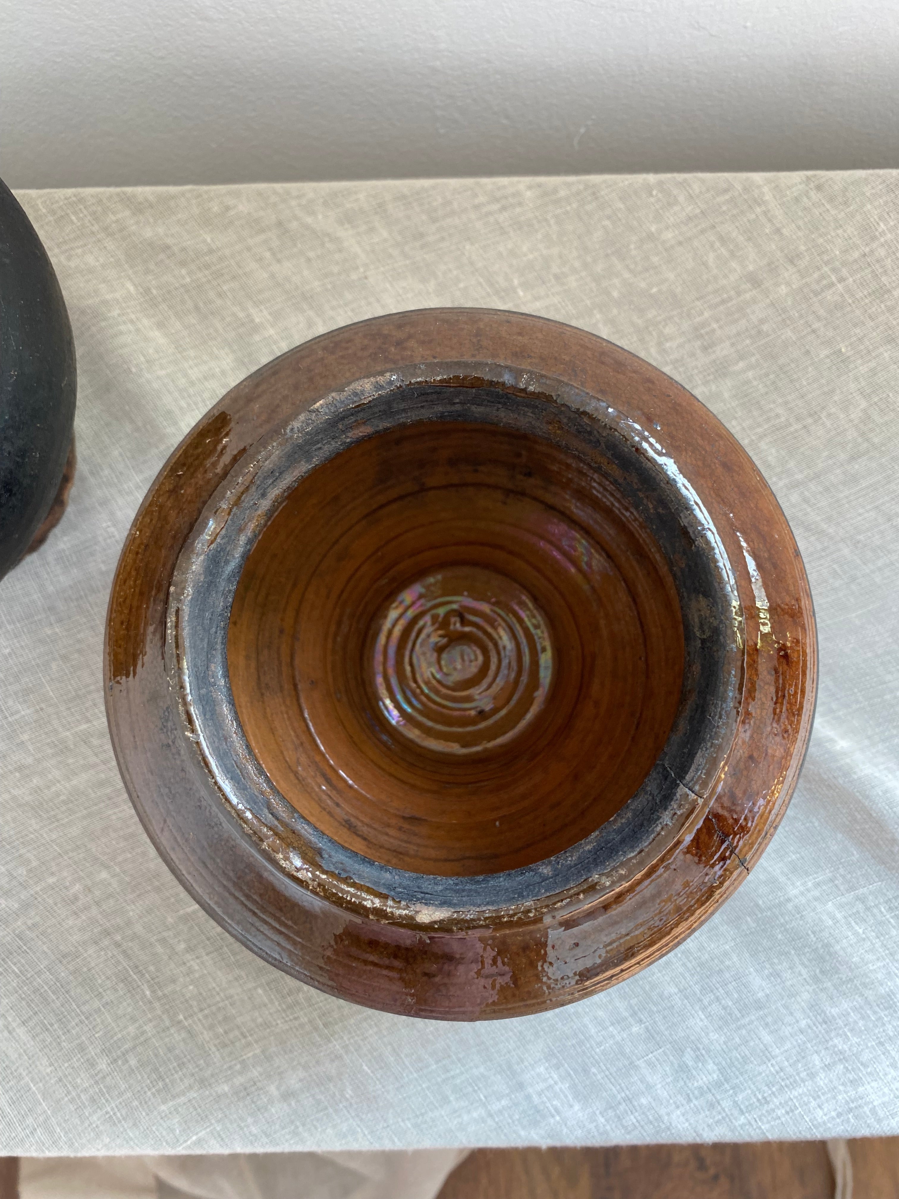 Brown antique terracotta clay  pot on a white surface