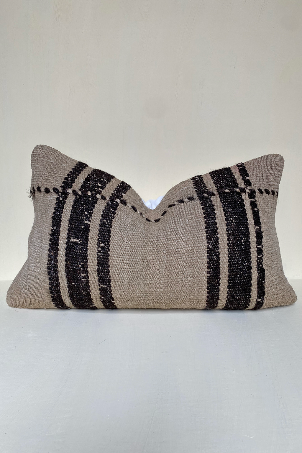 Vintage striped kilim cushion in taupe beige and black tones, handwoven lumbar pillow perfect for rustic living rooms and neutral interiors.