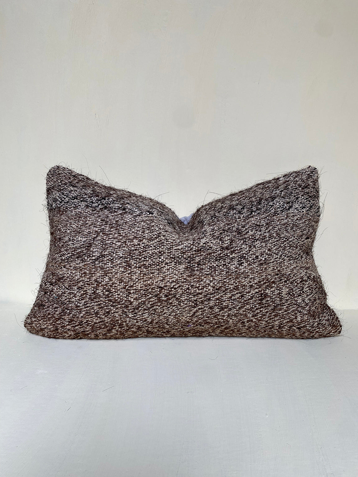 Handwoven brown kilim cushion with natural wool and goat hair blend, textured for rustic interiors. A vintage-style lumbar cushion for neutral home decor.
