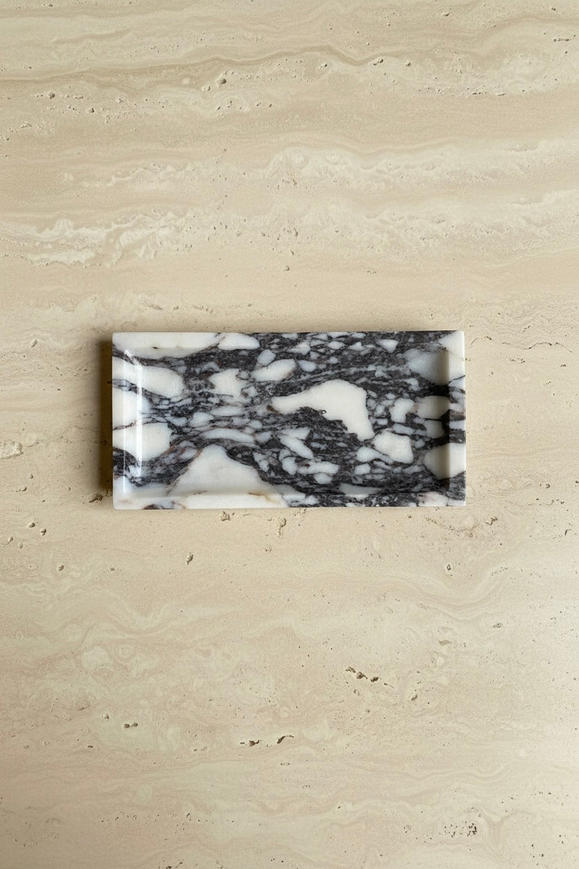 Marble-veined rectangular tray on a travertine table