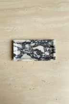 Marble-veined rectangular tray on a travertine table