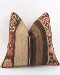 A square Turkish Kilim pillow cover featuring a traditional kilim pattern in shades of brown, beige, and muted red, set against a plain white background.