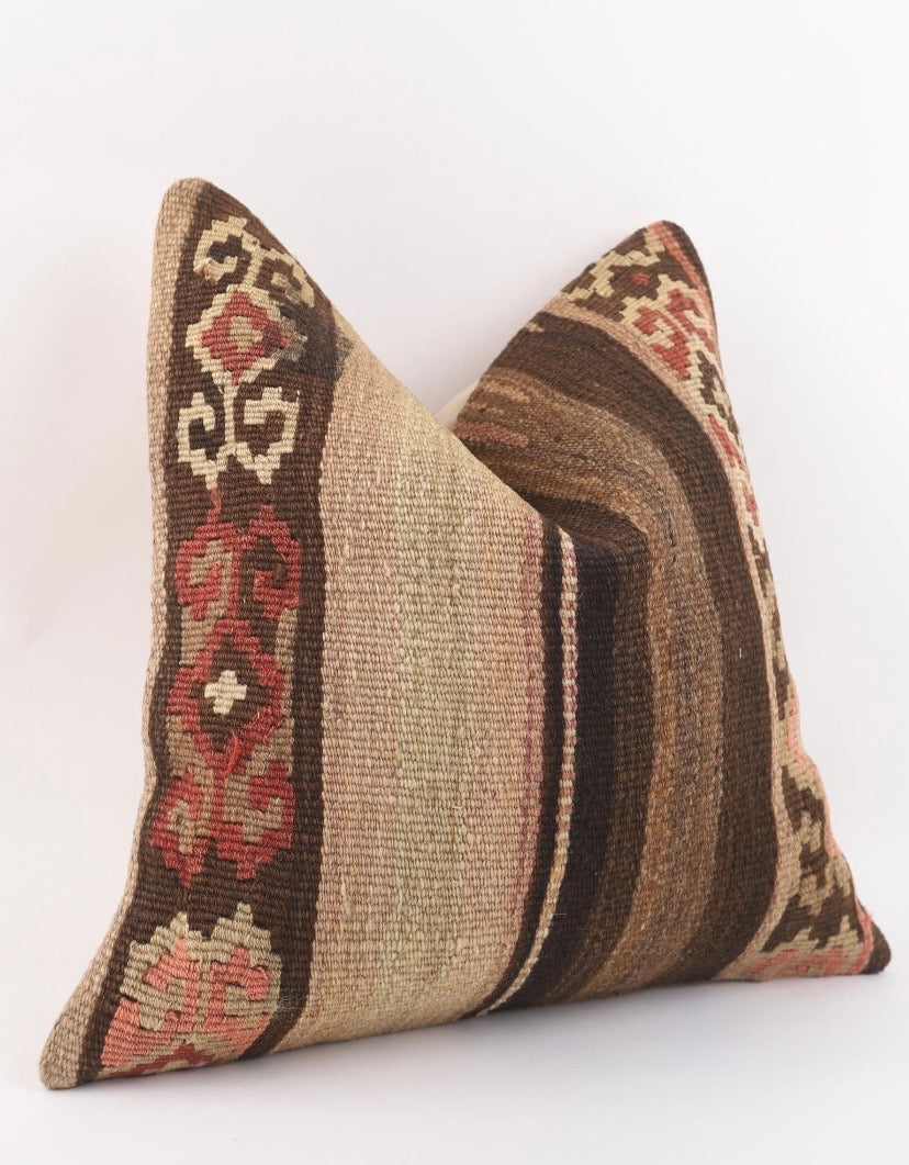 A square Turkish kilim pillow cover with a woven tribal pattern in brown, beige, and red, shown against a plain white background.