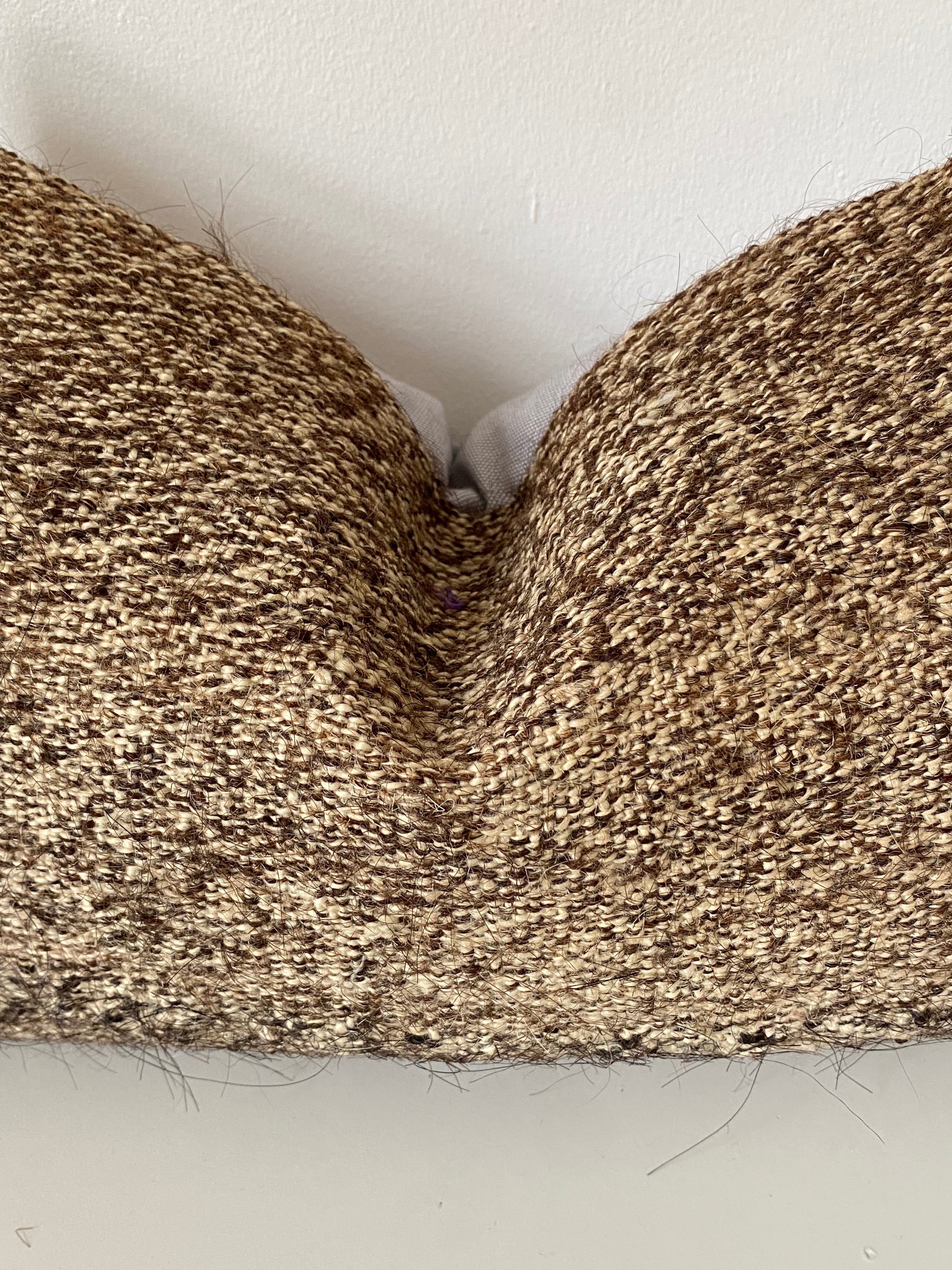 Close-up of a textured brown Turkish Pillow cover on a light grey background