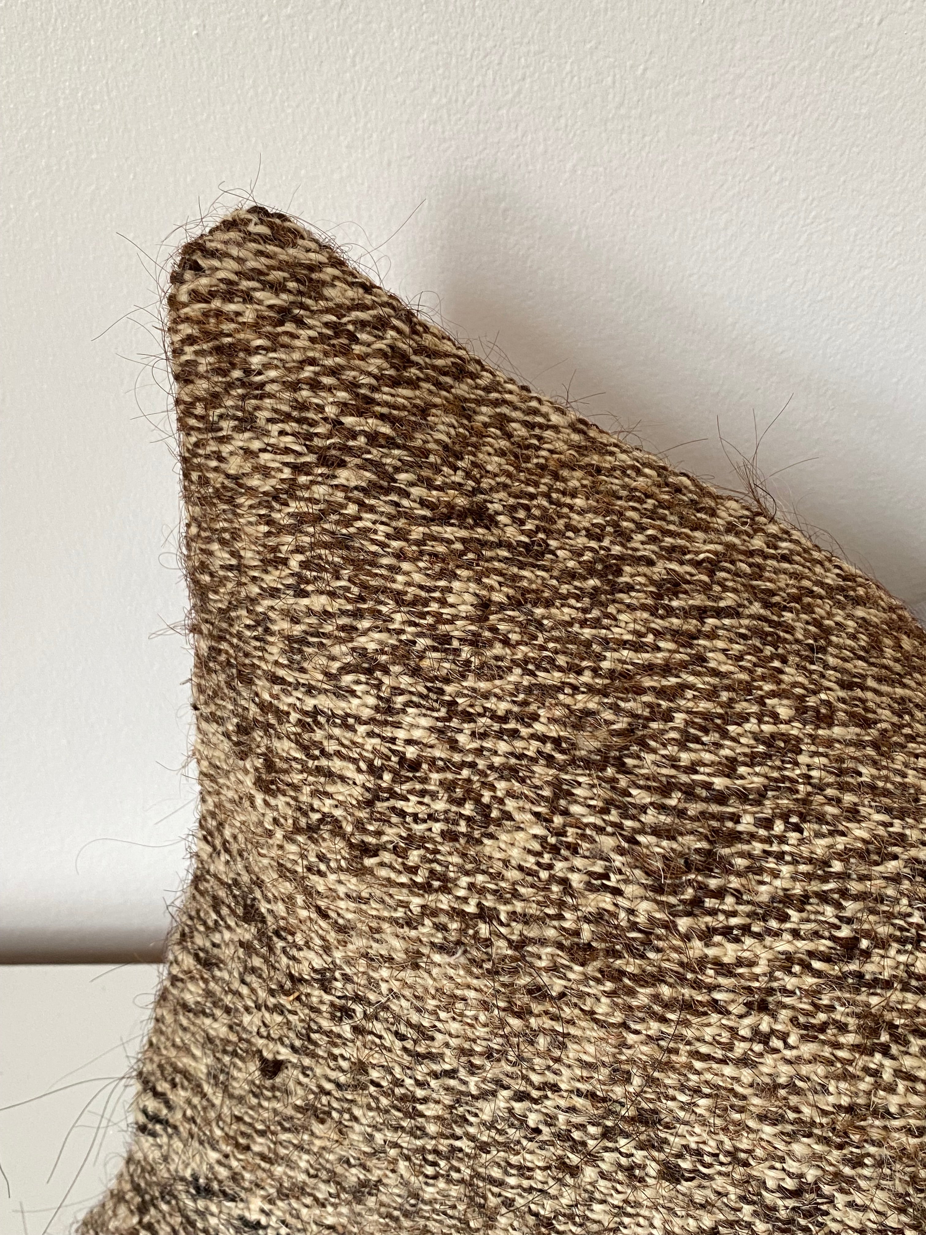 Close-up of a textured brown Turkish pillow cover on a light background