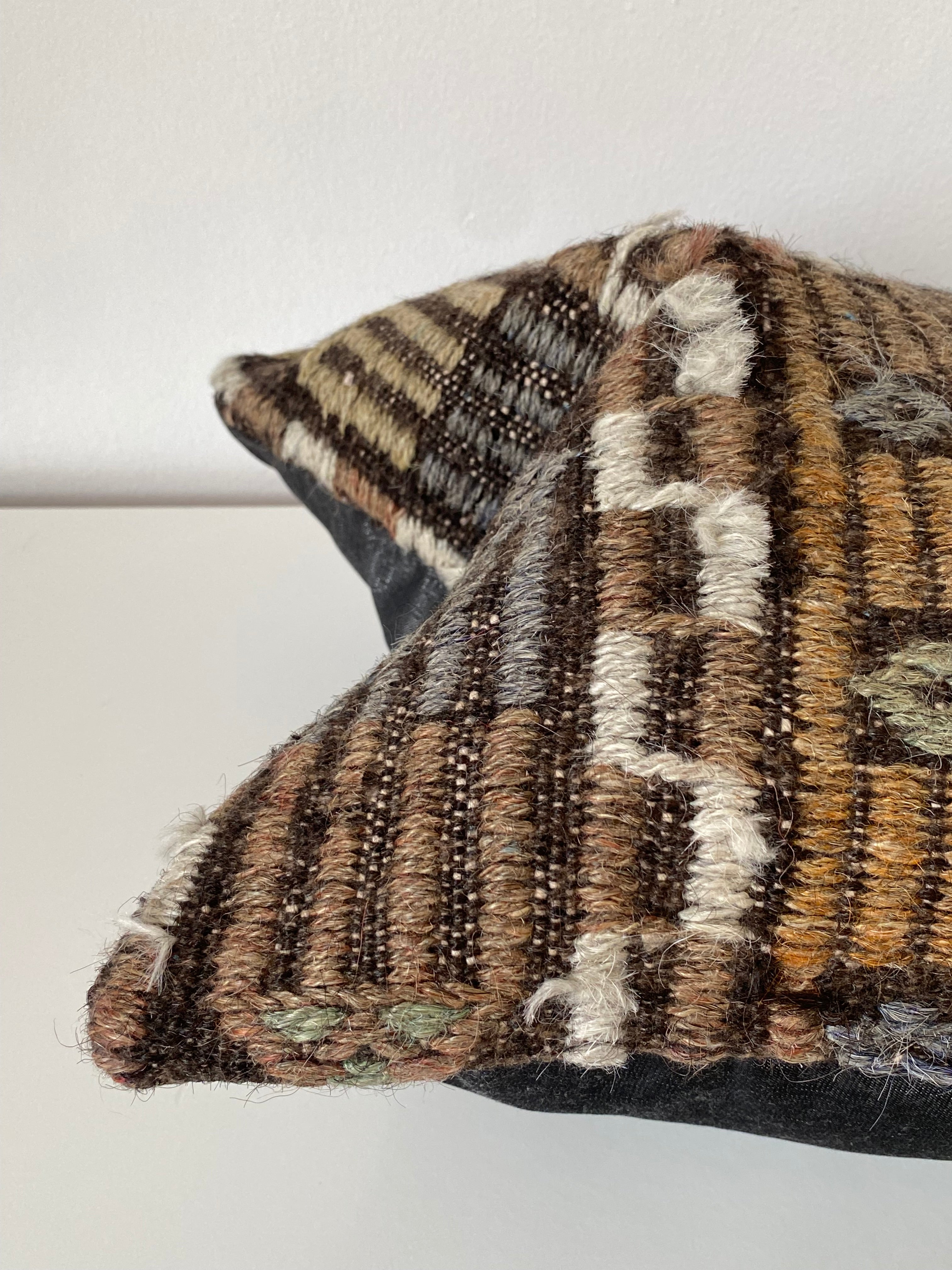 Textile Turkish kilim pillow cover with geometric pattern on a plain white background