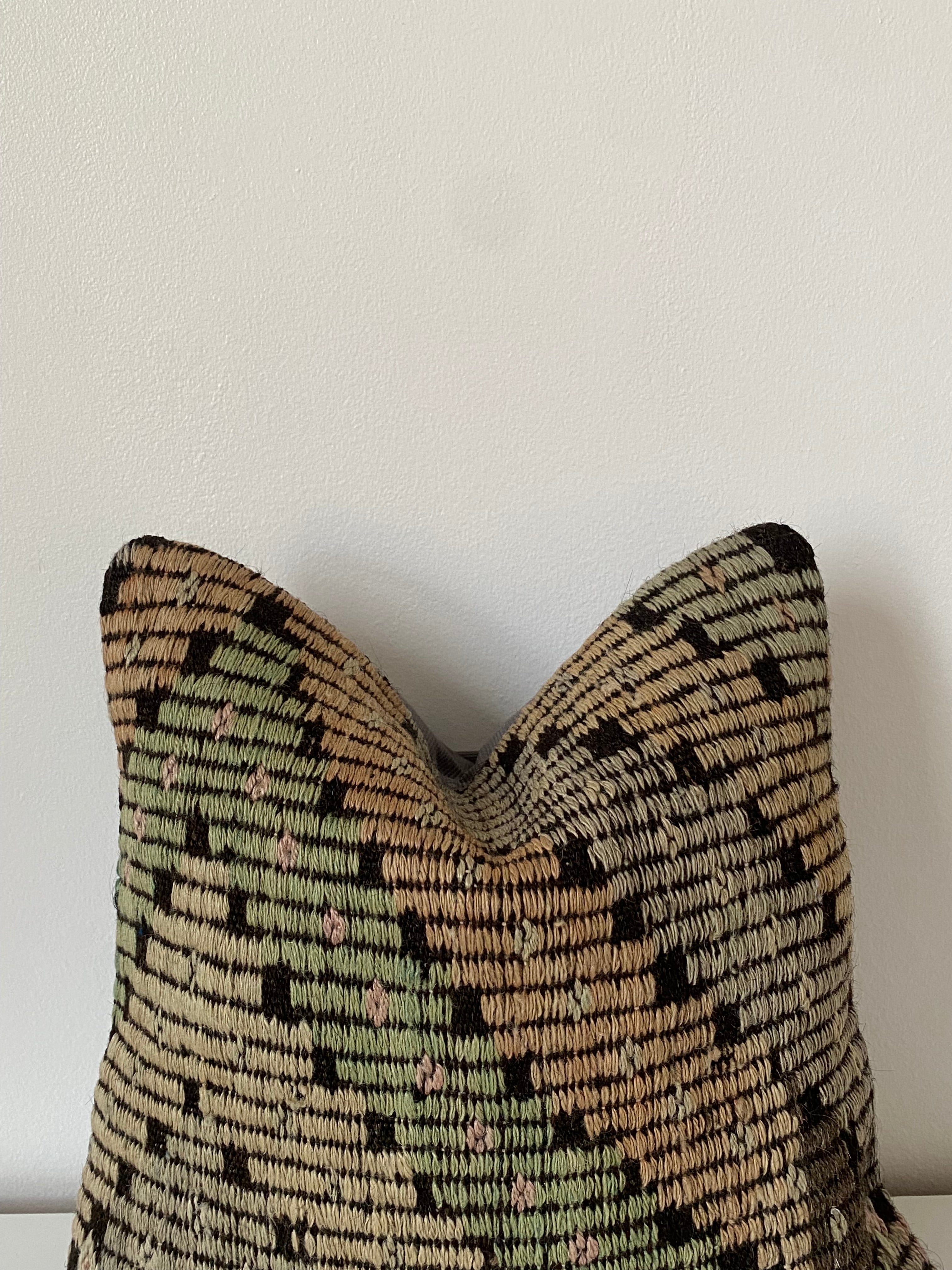 Textured Turkish kilim pillow cover with geometric pattern on a light background