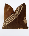 A square decorative brown Turkish Pillow cover made from a brown and beige woven kilim fabric with geometric patterns, shown against a plain white background.