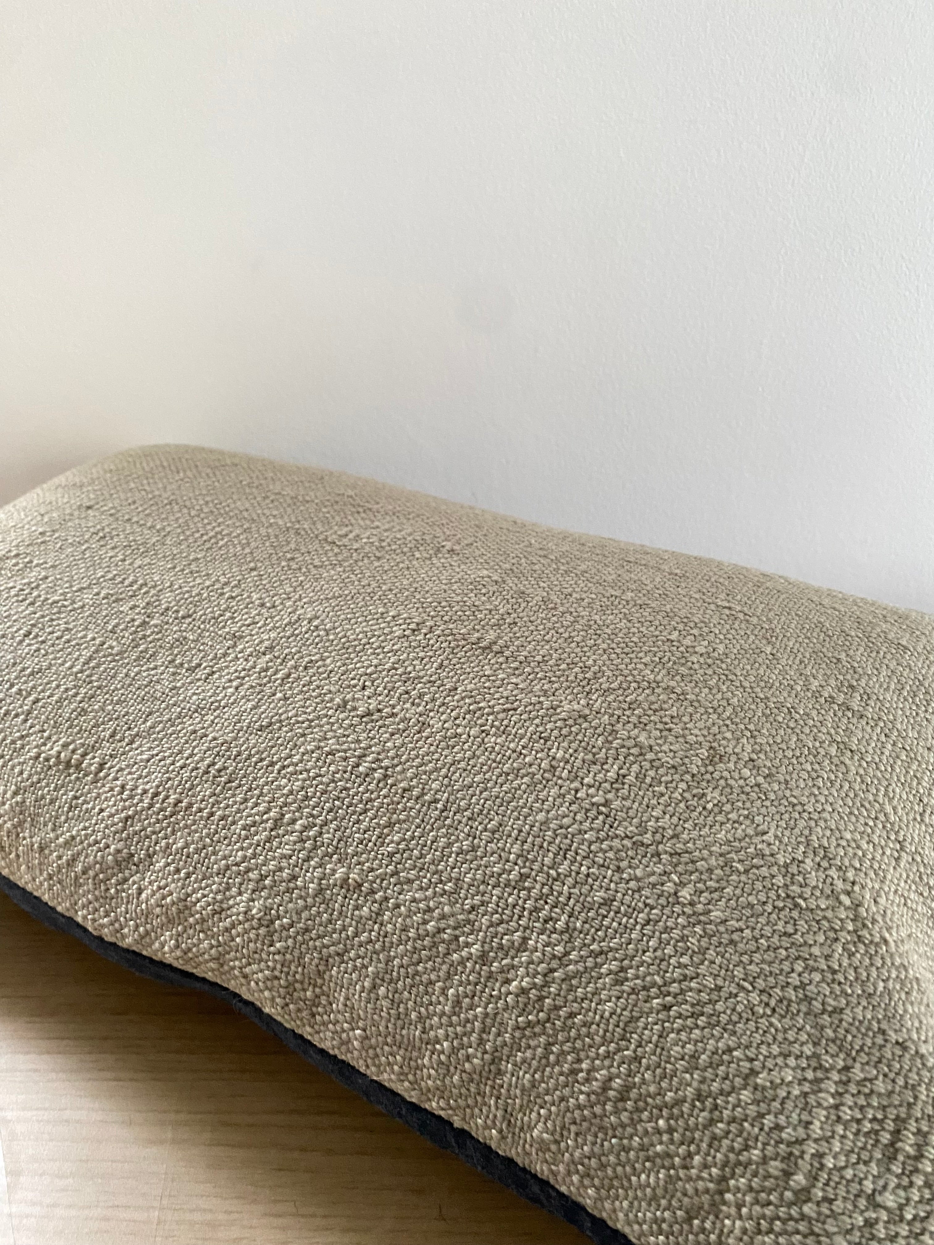 Turkish Kilim Lumbar Textured rectangular pillow on a light wooden surface with a neutral background