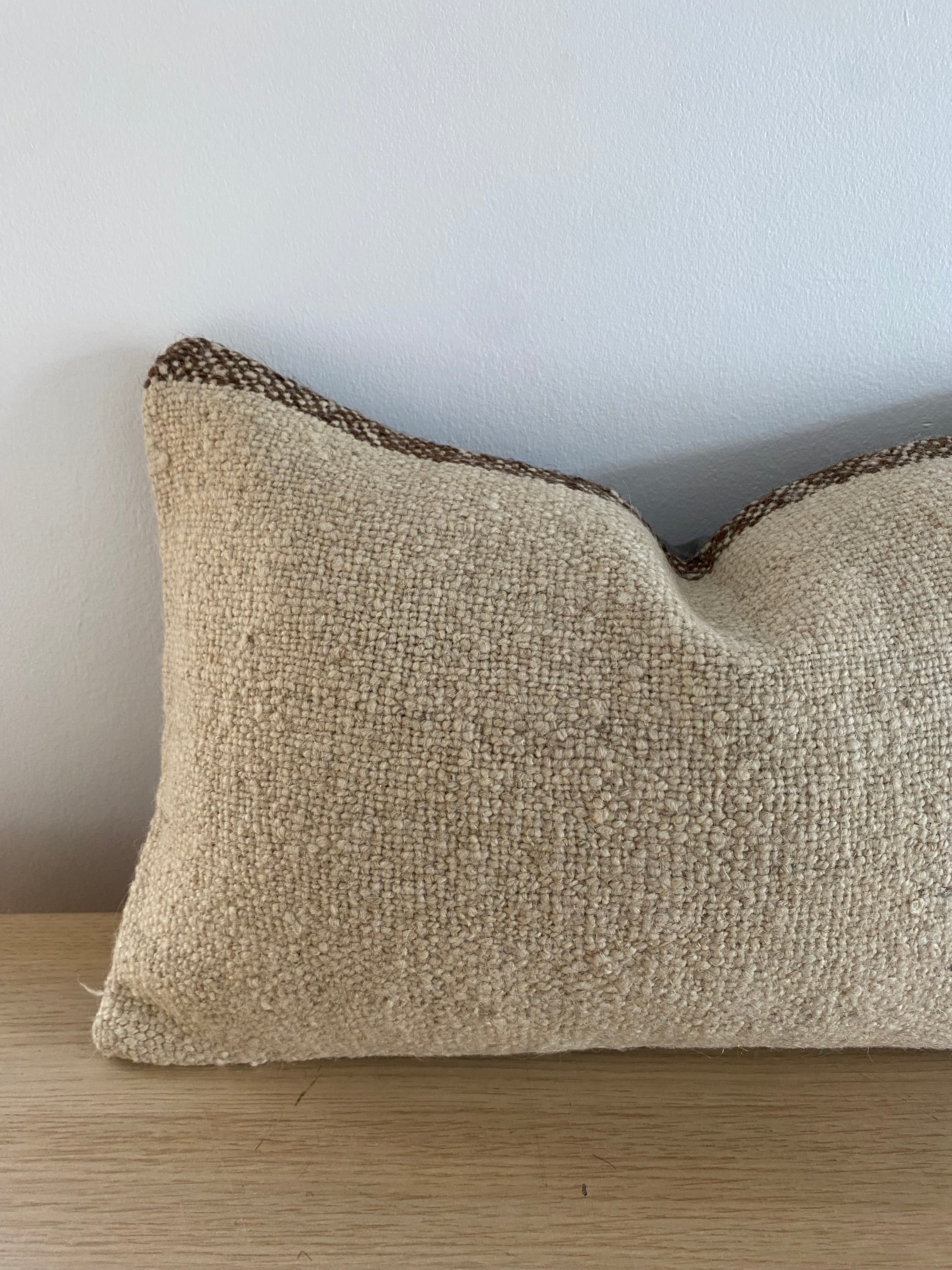 Turkish Kilim Textured beige pillow cover  on a light blue background