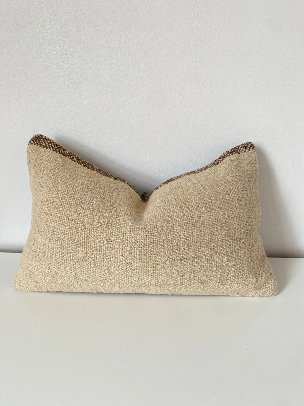 Textured beige Turkish Kilim pillow cover on a white background
