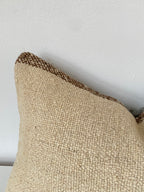 Textured Beige Turkish pillow cover with brown trim on a light grey background
