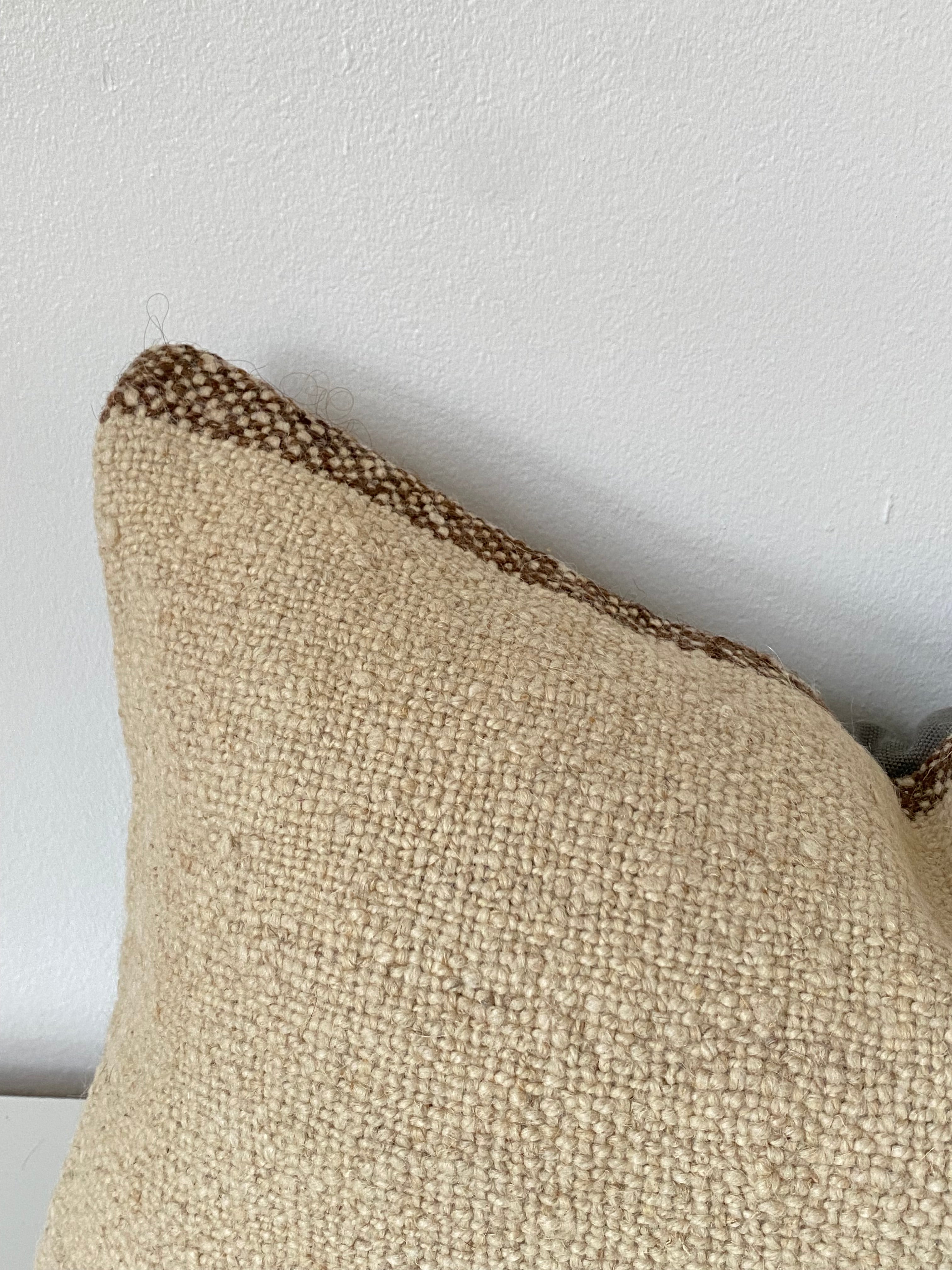 Textured Beige Turkish pillow cover with brown trim on a light grey background