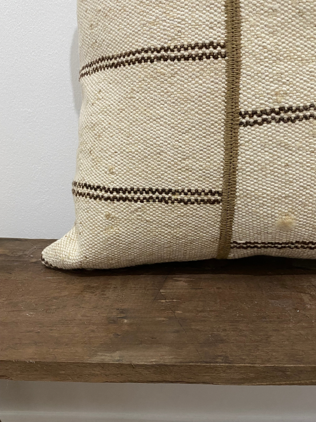 Textured pillow with brown stripes on a wooden surface