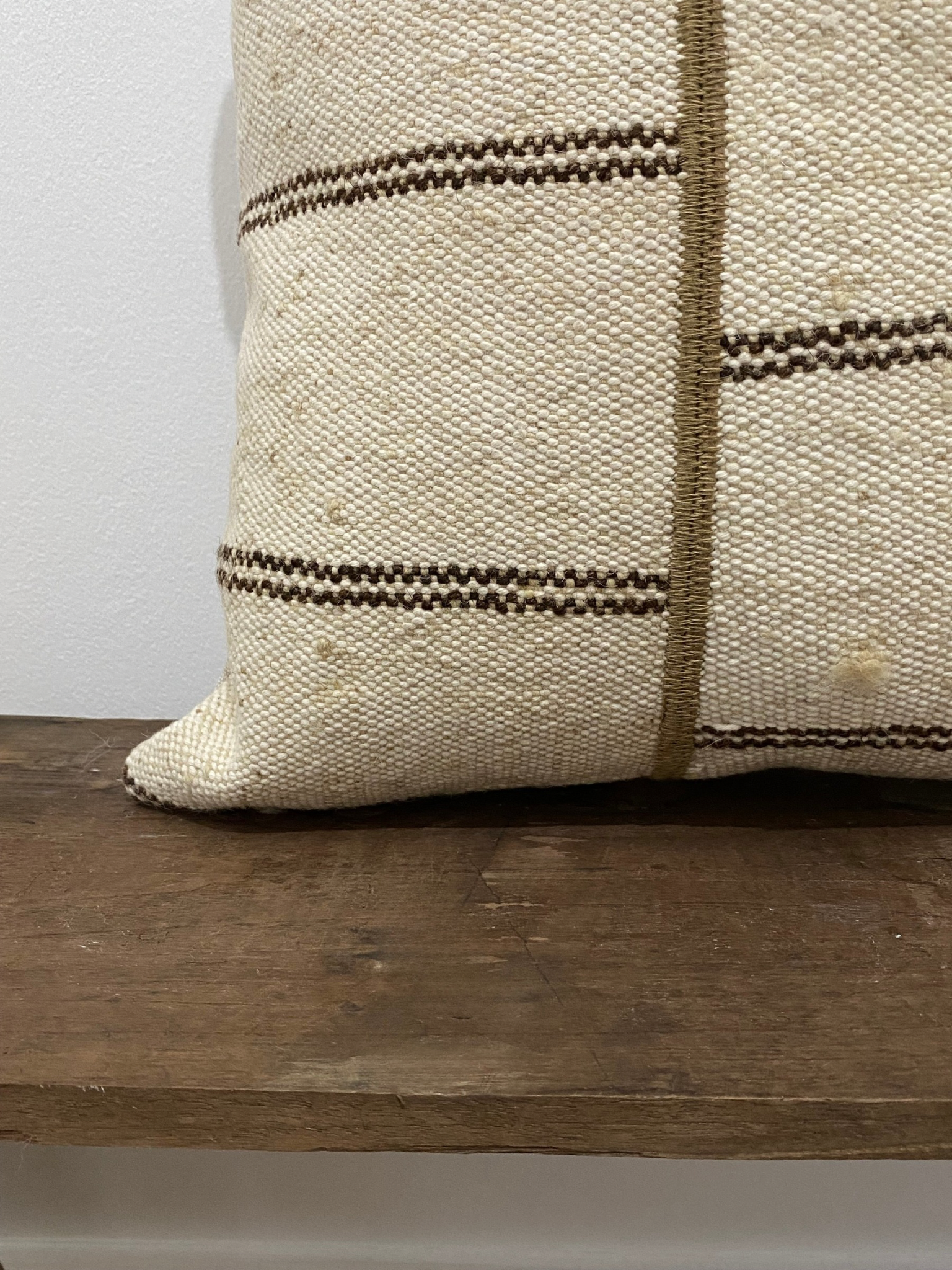 Textured pillow with brown stripes on a wooden surface