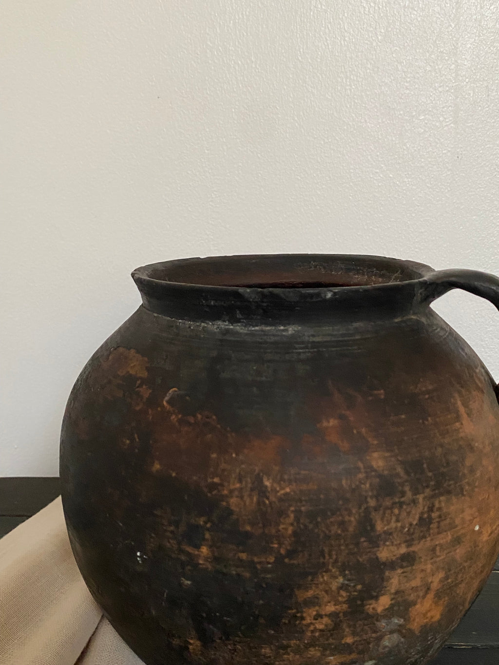 Rust-coloured antique clay pot on a white background