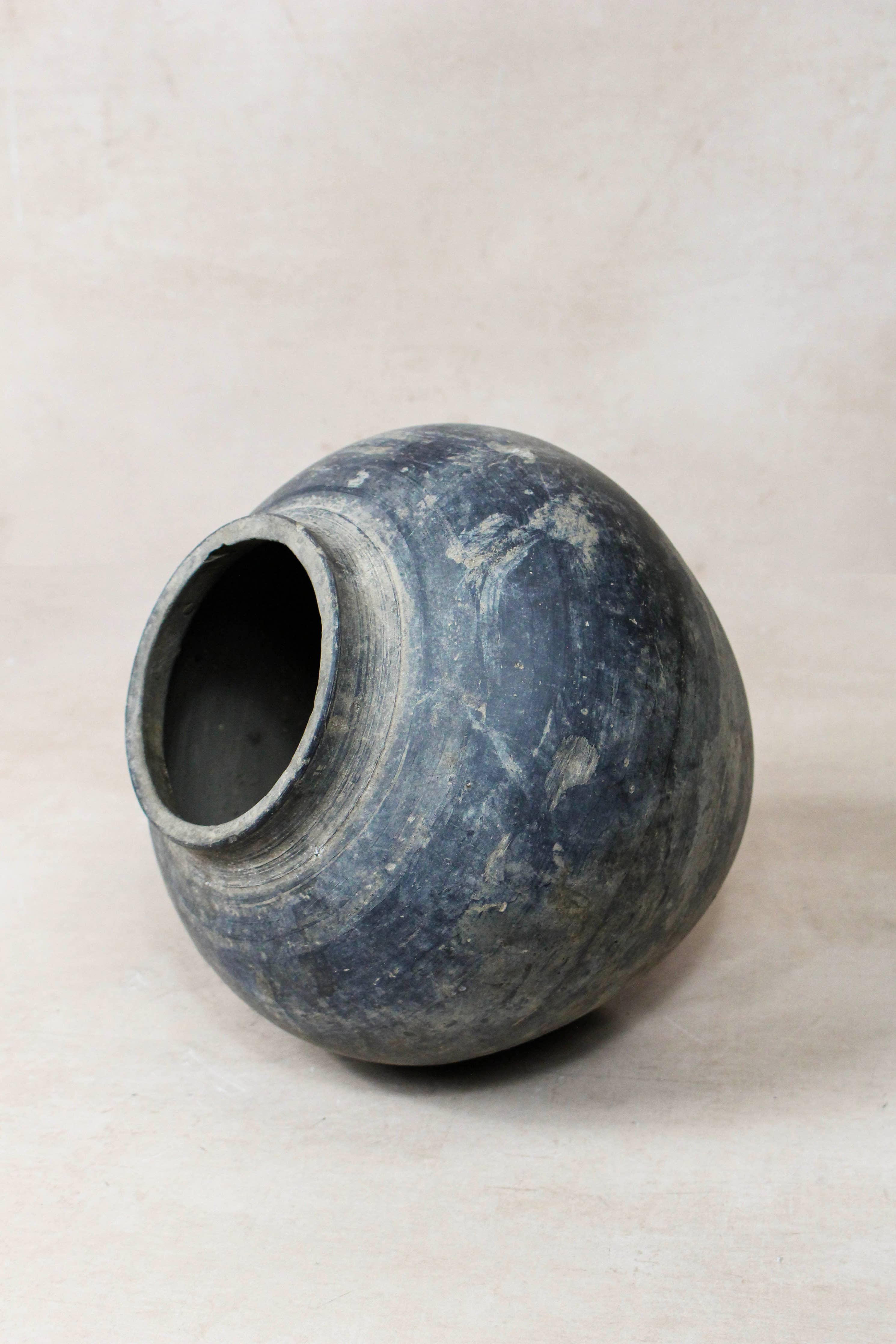 Dark grey antique clay pot on a white background