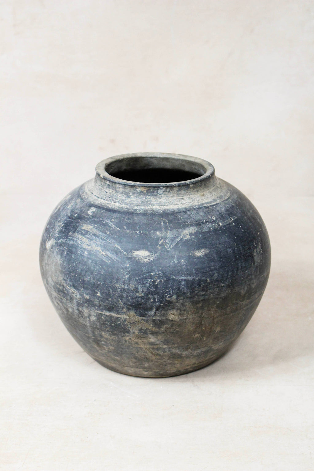 Dark grey antique terracotta clay pot on a white background