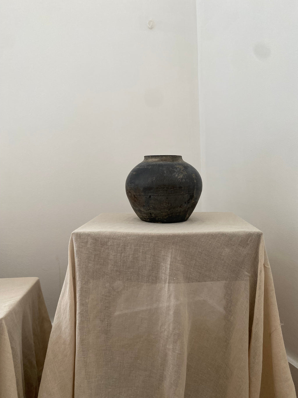Antique clay pot on light beige fabric 
