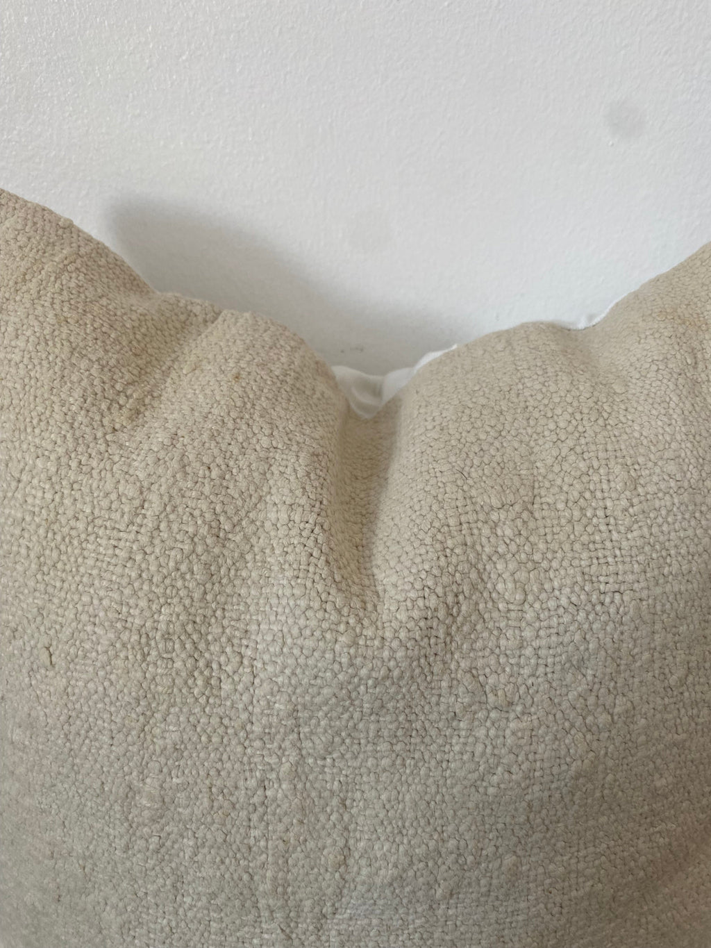 Textured off white pillow cover on a white background