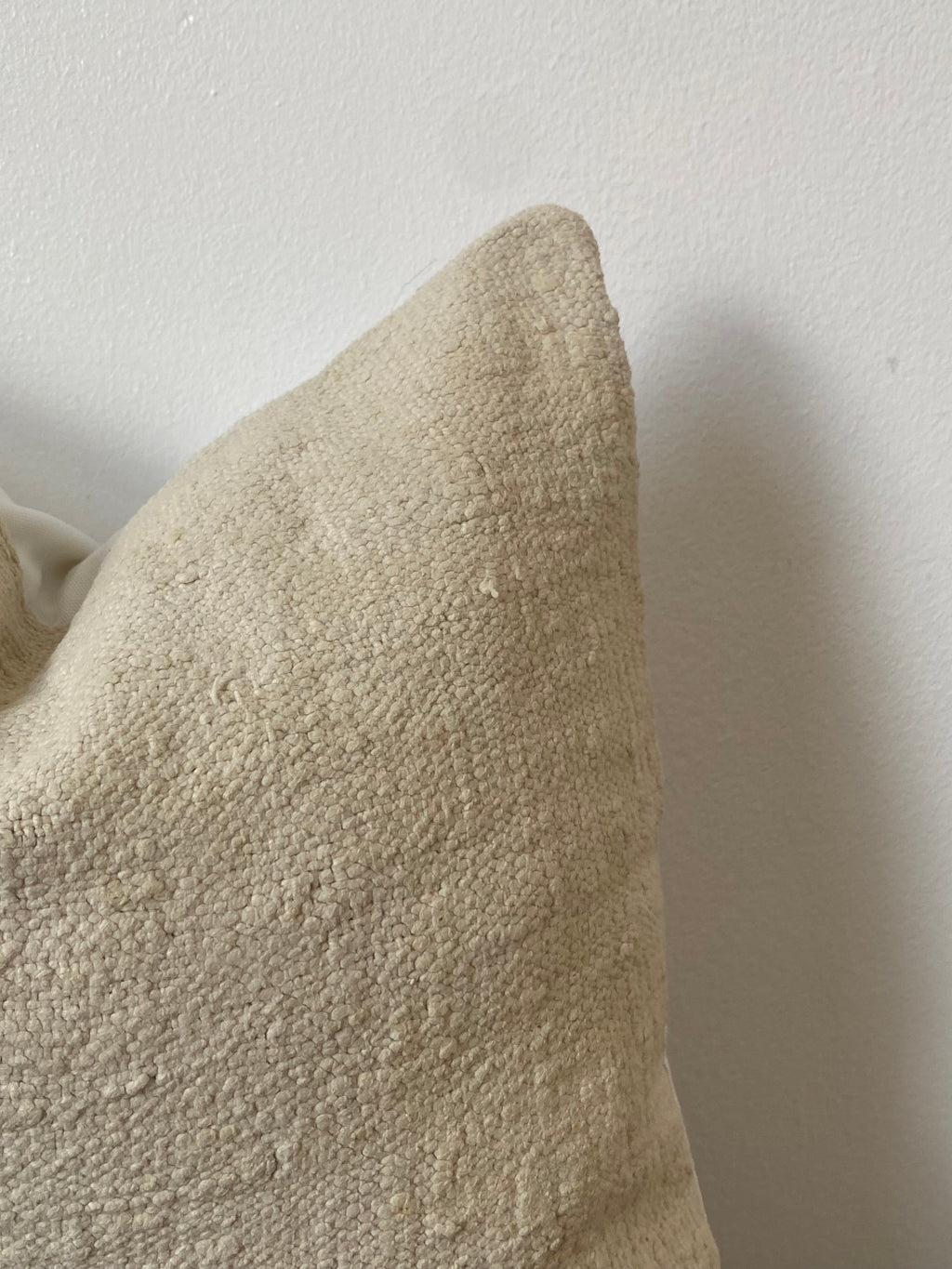 Textured off white pillow cover on a wooden table