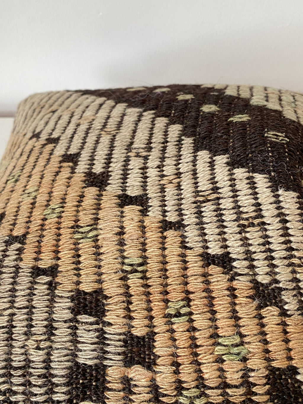 Close-up of a Turkish Kilim pillow cover with geometric pattern on a white background