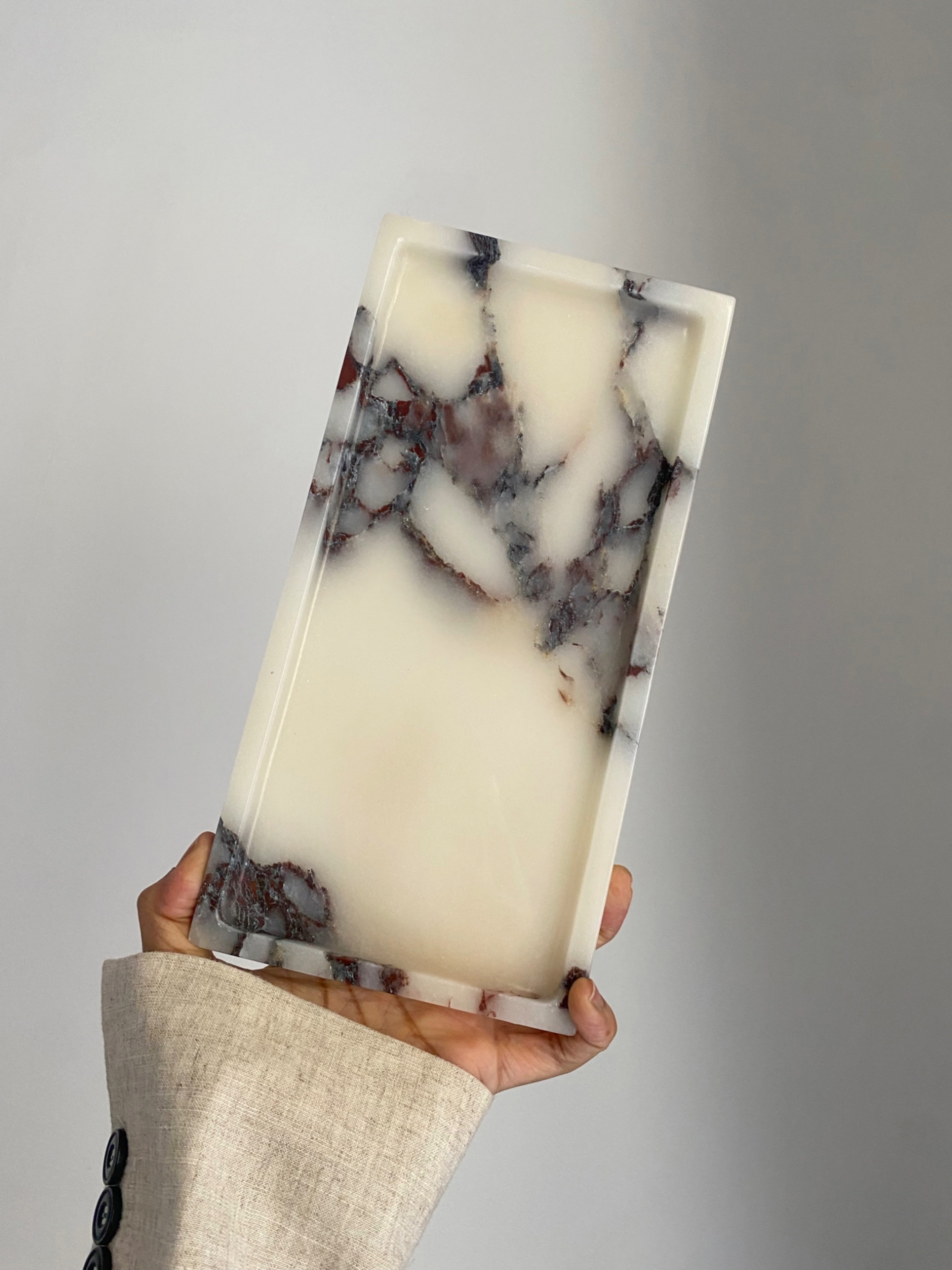 Rectangular Marble-patterned phone case held by a person against a white background